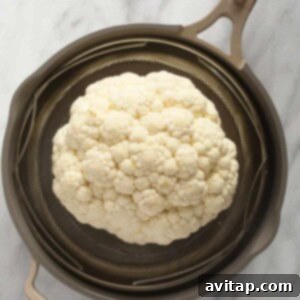 a head of cauliflower in a strainer.