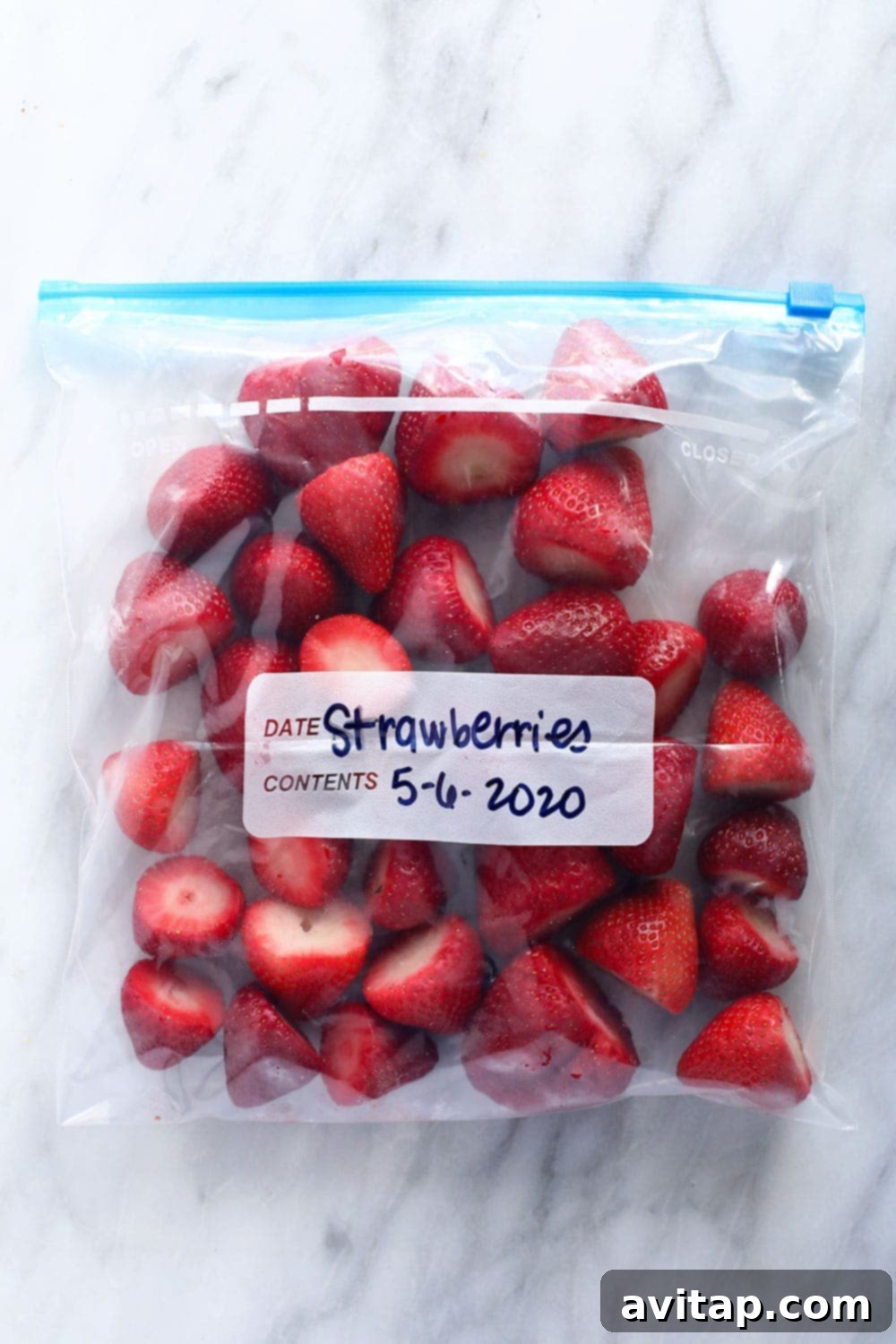 A bag filled with perfectly frozen strawberries, ready for future use.