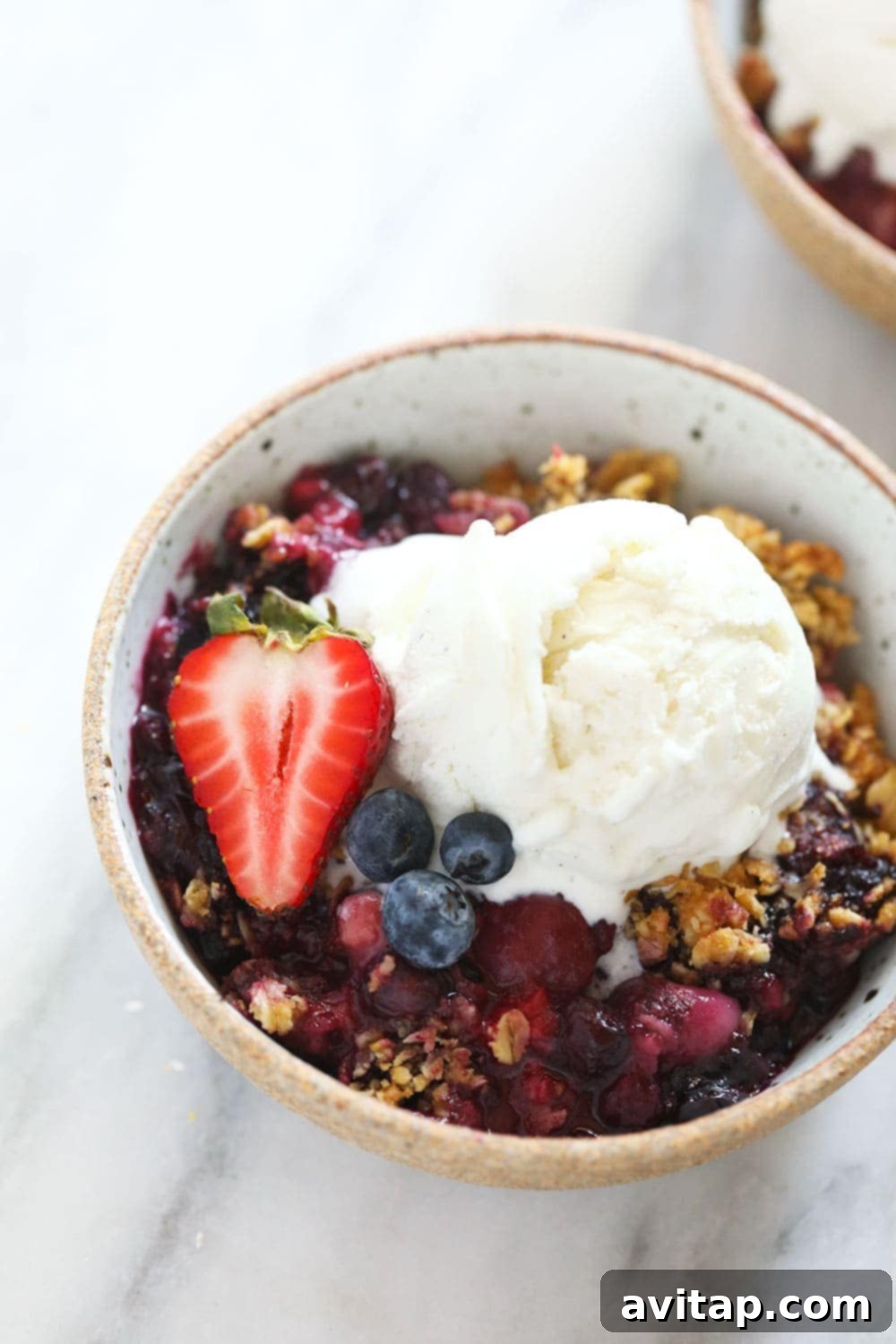 bowl of berry crisp with vanilla ice cream