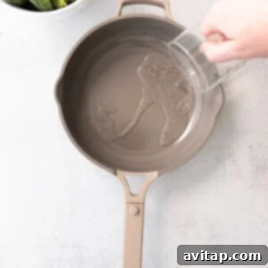 a person pouring water into a frying pan.