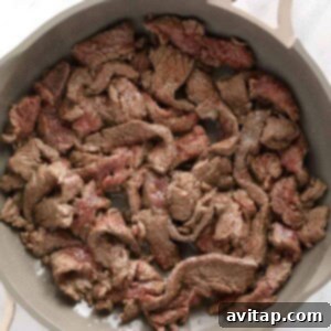 Effortless Creamy Beef Stroganoff 11 A skillet full of seared beef strips, perfect for beef stroganoff.