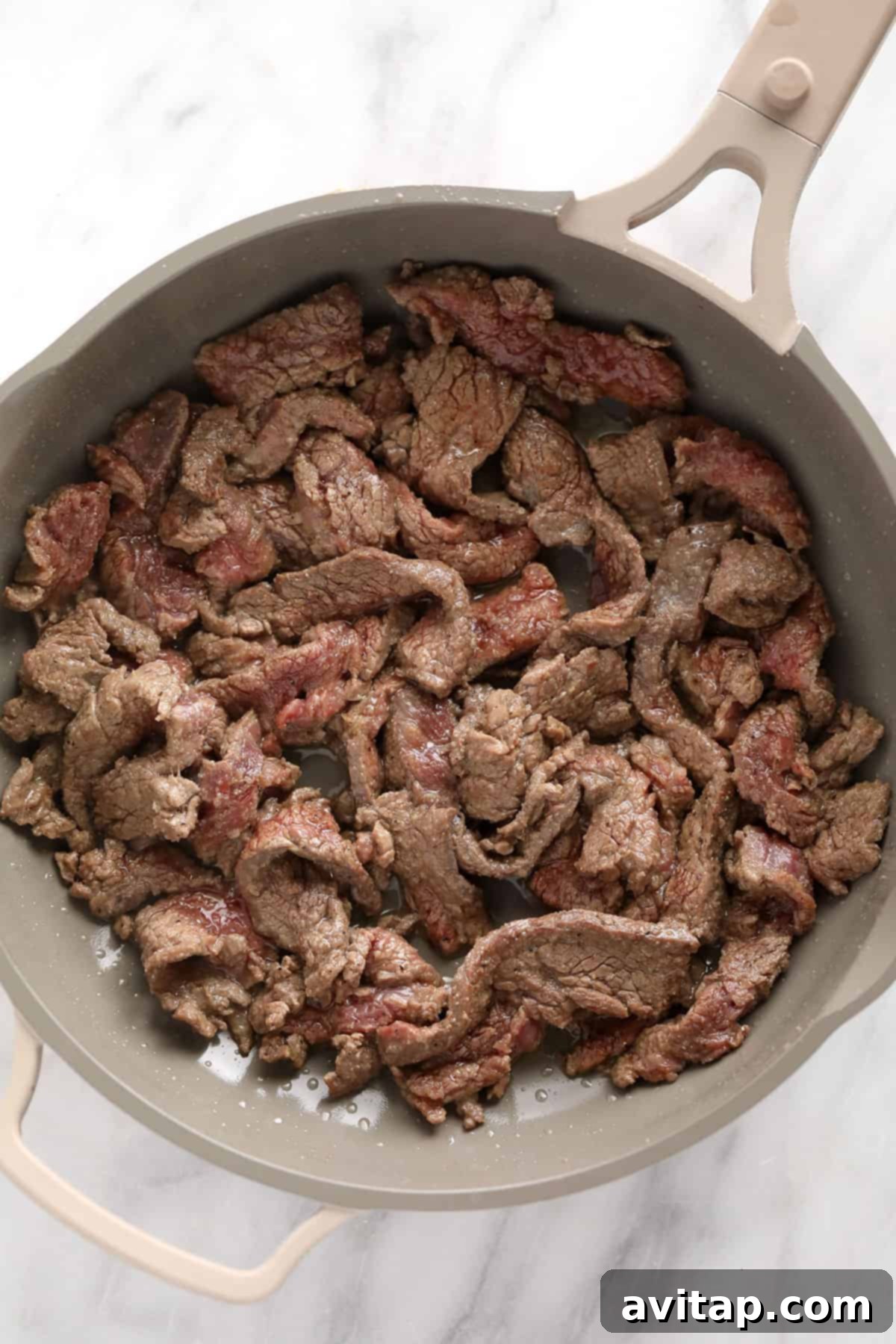Effortless Creamy Beef Stroganoff 4 Thinly sliced beef strips being seared in a hot pan, preparing for the stroganoff sauce.