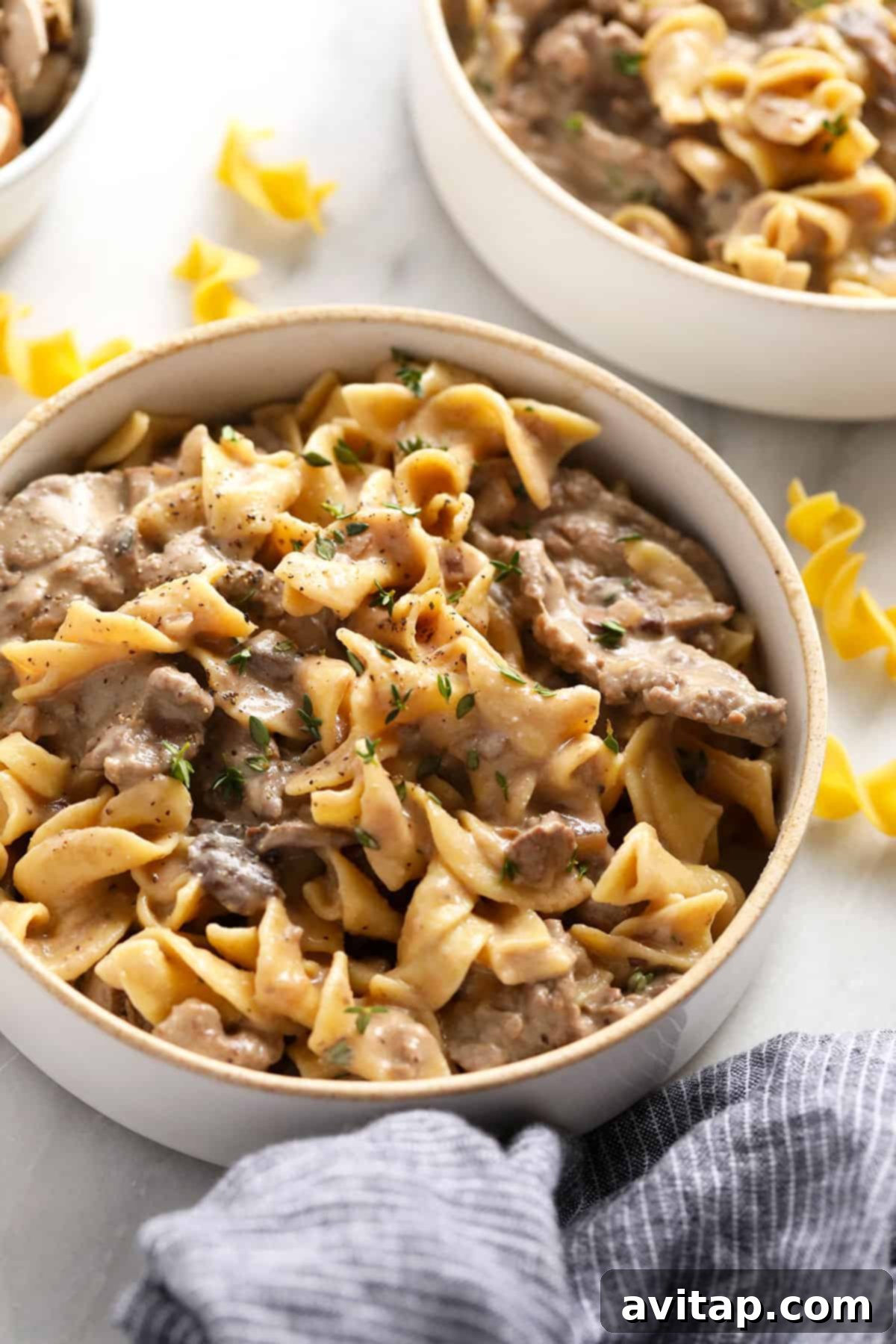 Effortless Creamy Beef Stroganoff 8 A bowl of classic beef stroganoff, garnished with fresh herbs, ready to be enjoyed.