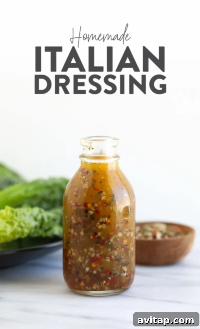 Zesty Homemade Italian Dressing 2 Italian dressing in a clear glass jar with fresh herbs around it.