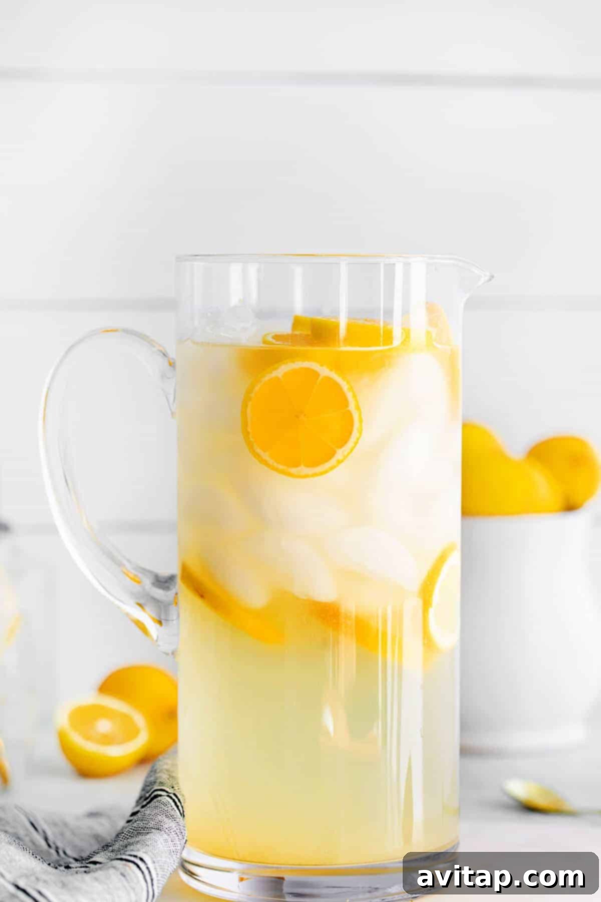 A large, inviting pitcher of homemade lemonade, with ice and vibrant lemon slices gracefully floating, promising a refreshing experience.