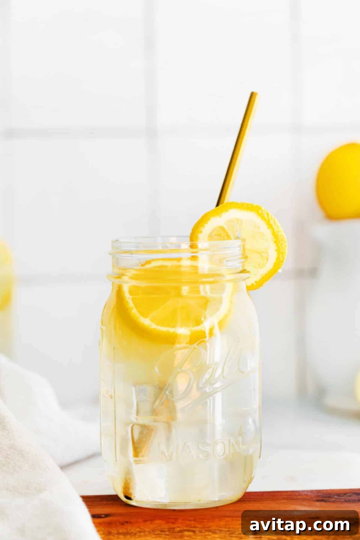 A rustic mason jar filled to the brim with homemade lemonade, showcasing its delightful clarity and promise of refreshment.