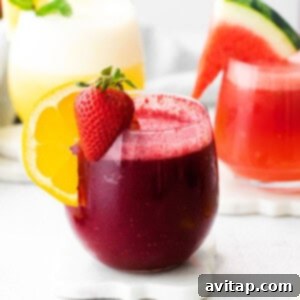 Three colorful wine slushies in glasses, garnished with various fruits, ready to be enjoyed.