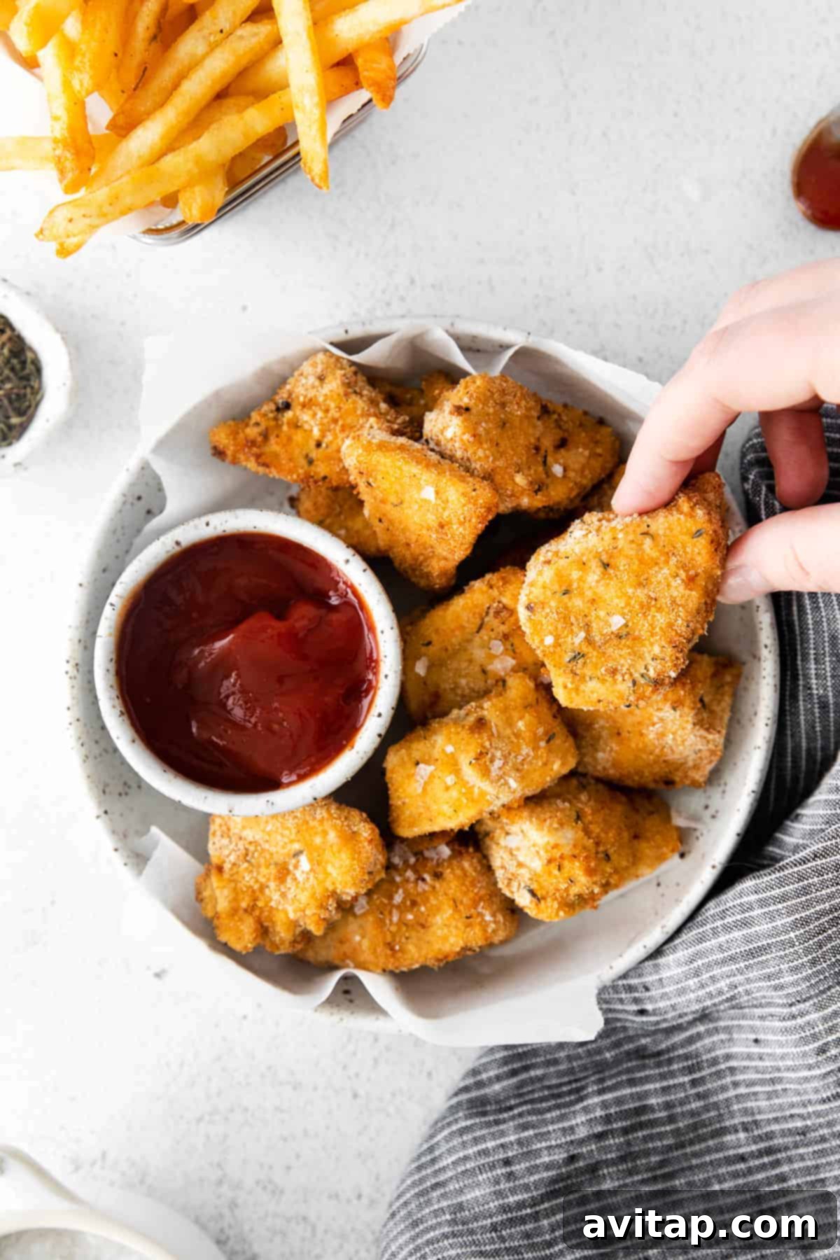 Crispy Air Fryer Chicken Nuggets served with a side of BBQ sauce, showcasing their golden-brown perfection.