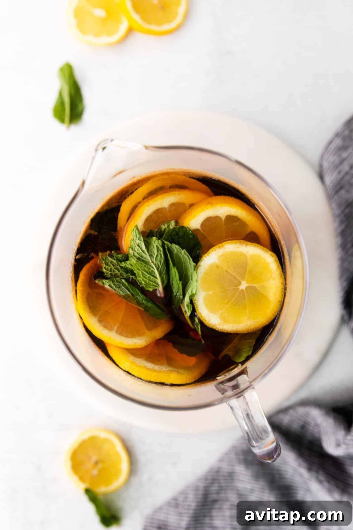 Homemade Iced Tea Pitcher pitcher of iced tea garnished with fresh lemons and mint