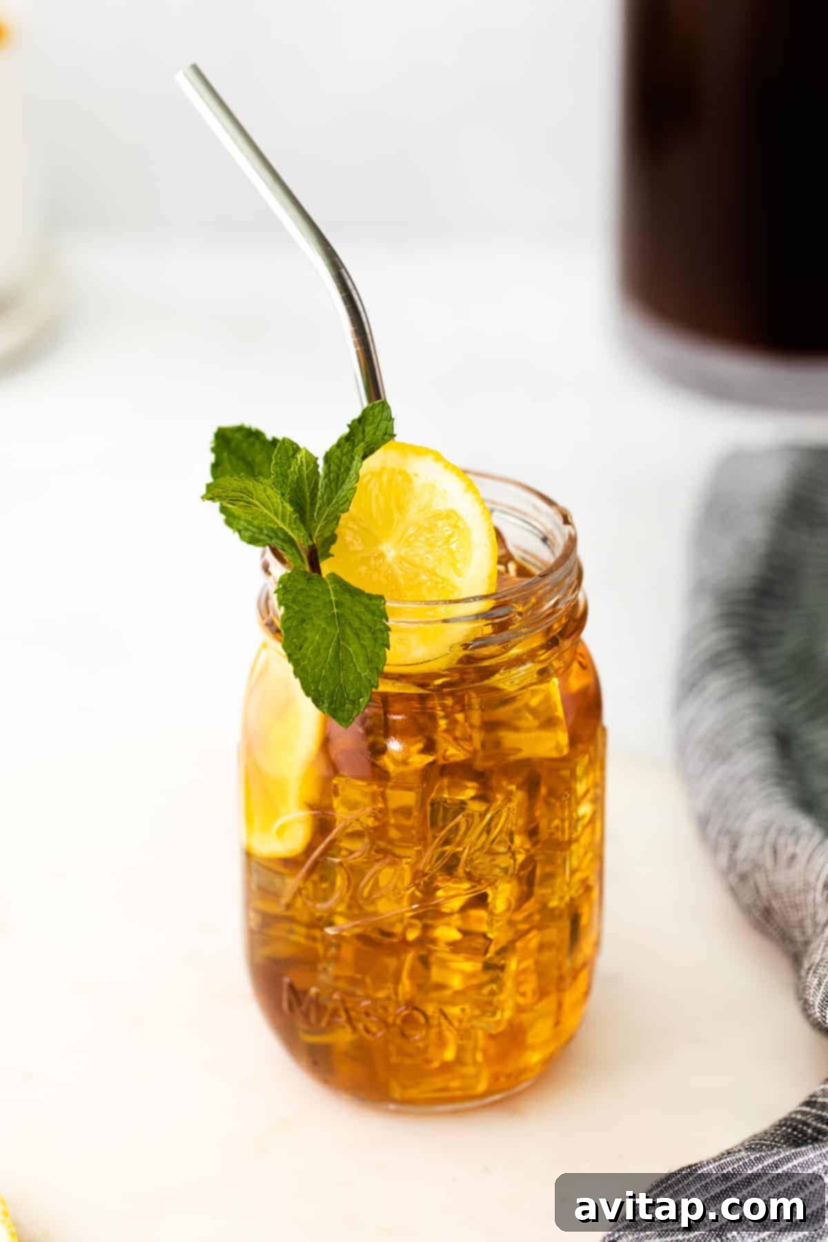 Iced Tea in Mason Jar mason jar of iced tea garnished with a slice of fresh lemon and a sprig of fresh mint