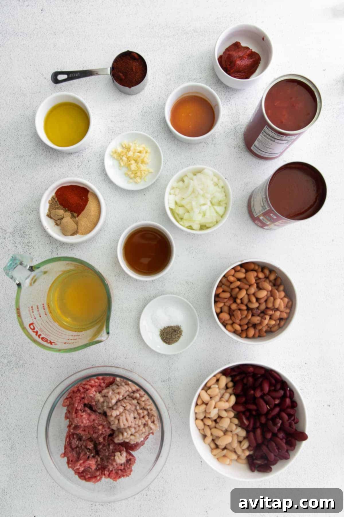 Whip up a batch of this delicious Instant Pot Chili in no time! This Instant Pot Chili recipe is made with ground beef, beans, tomato products, and homemade chili seasoning. Instant Pot chili ingredients neatly arranged in bowls, ready for cooking.