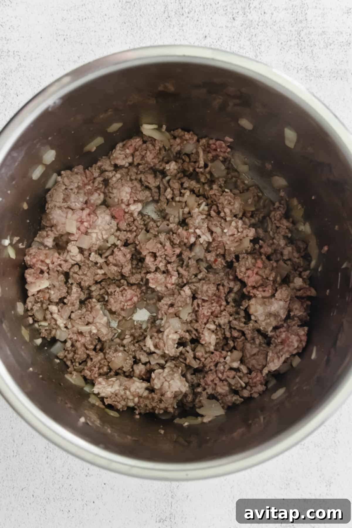 Whip up a batch of this delicious Instant Pot Chili in no time! This Instant Pot Chili recipe is made with ground beef, beans, tomato products, and homemade chili seasoning. Ground beef browning in the Instant Pot, preparing for chili.