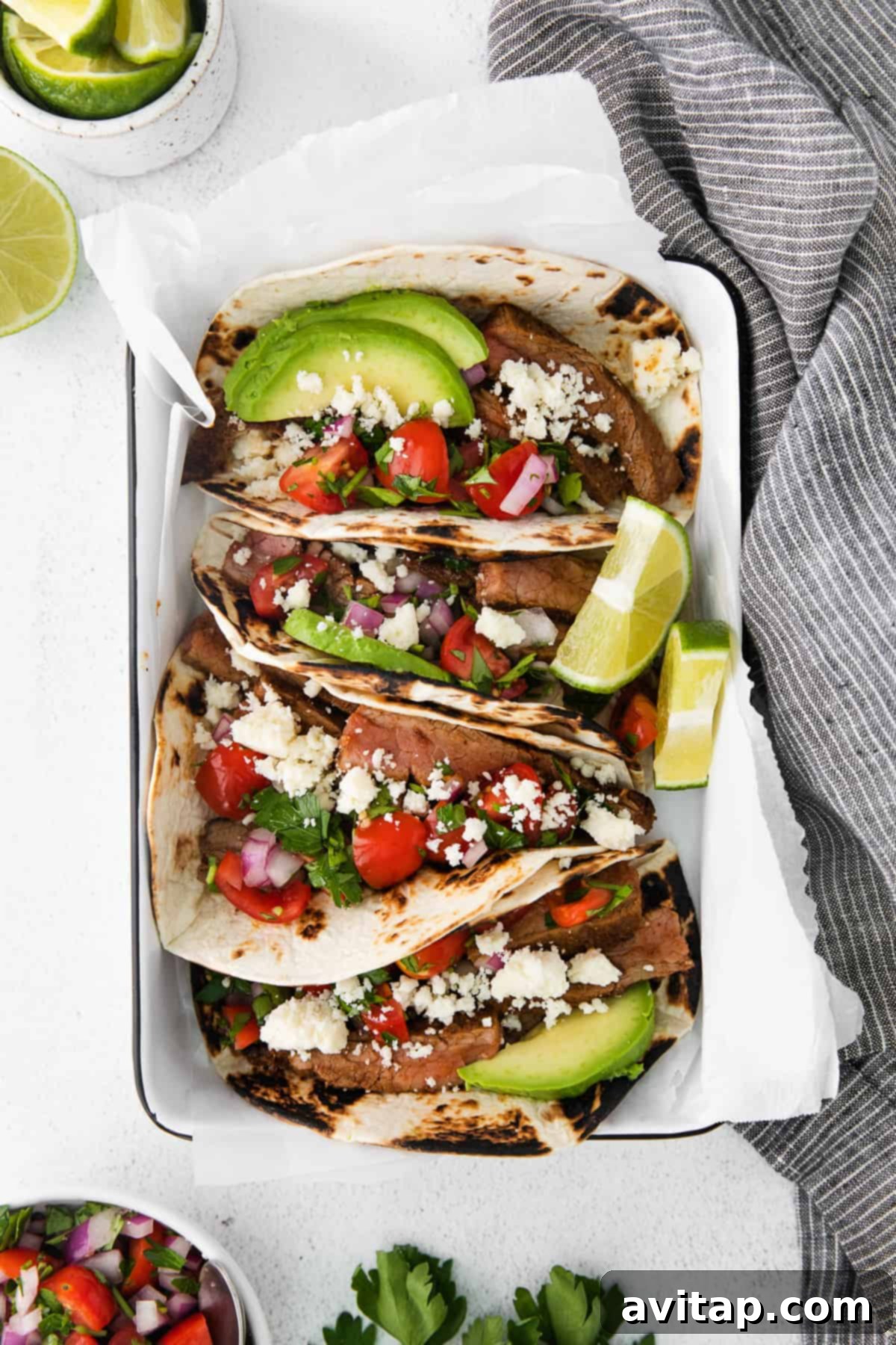 steak tacos topped with sliced avocado and cotija cheese