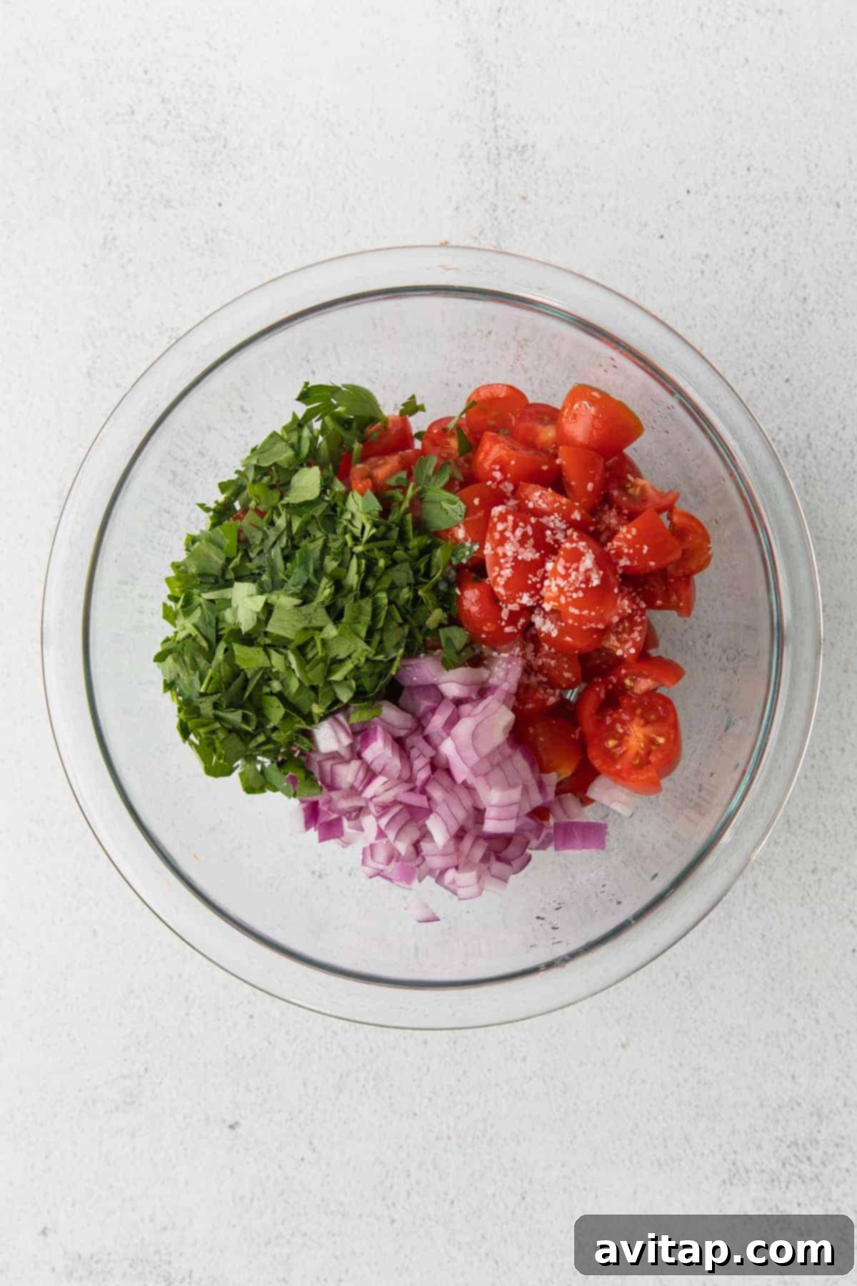 ingredients for tomato pico in a bowl, ready to be mixed together
