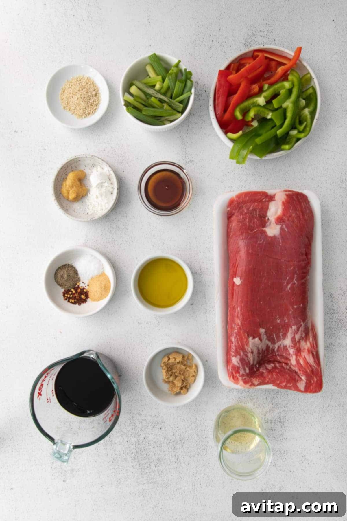 all the ingredients for pepper steak in small bowls.