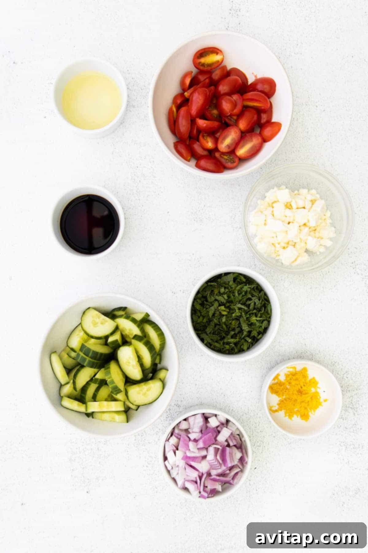 Selection of fresh ingredients for Mediterranean couscous salad laid out in small bowls