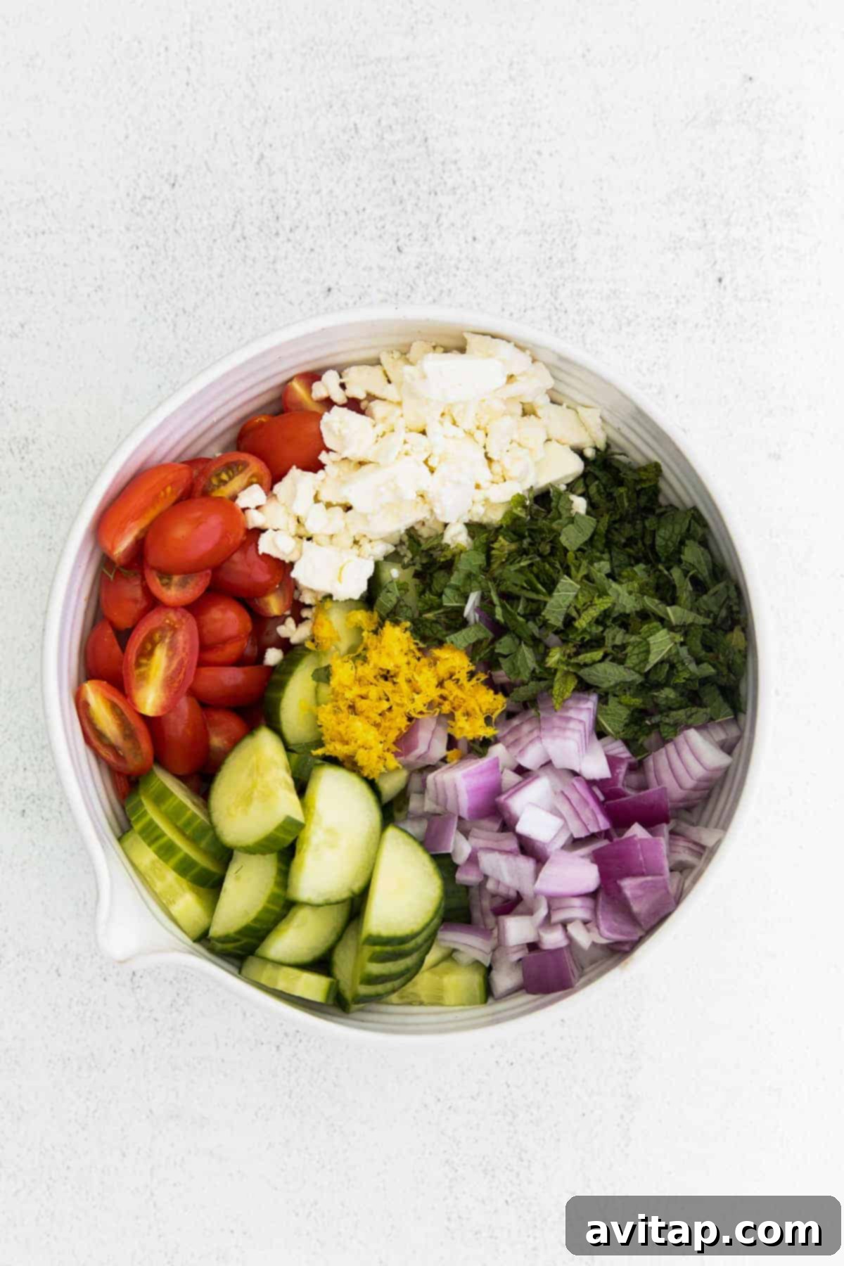 Assortment of fresh Mediterranean couscous salad ingredients in a mixing bowl