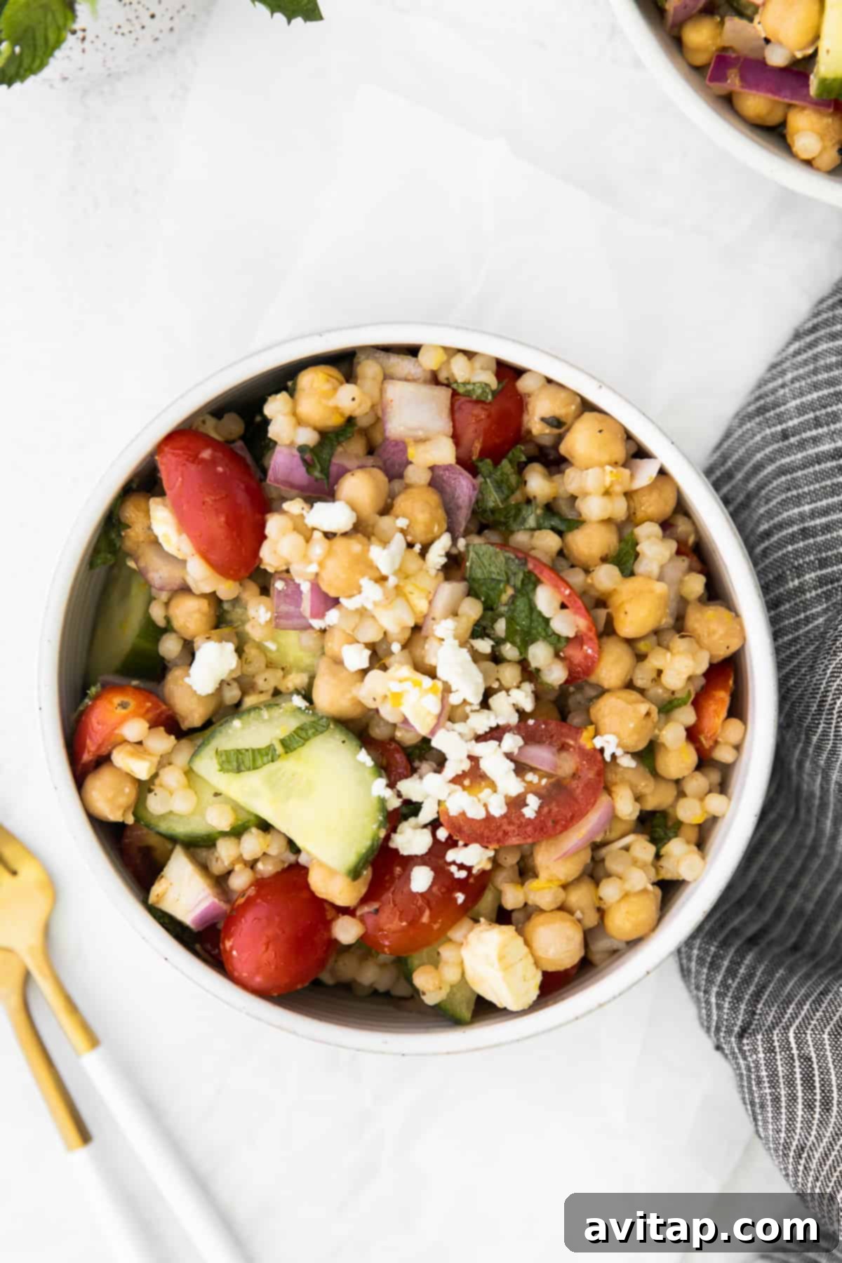 Individual serving of chilled Mediterranean couscous salad in a small bowl