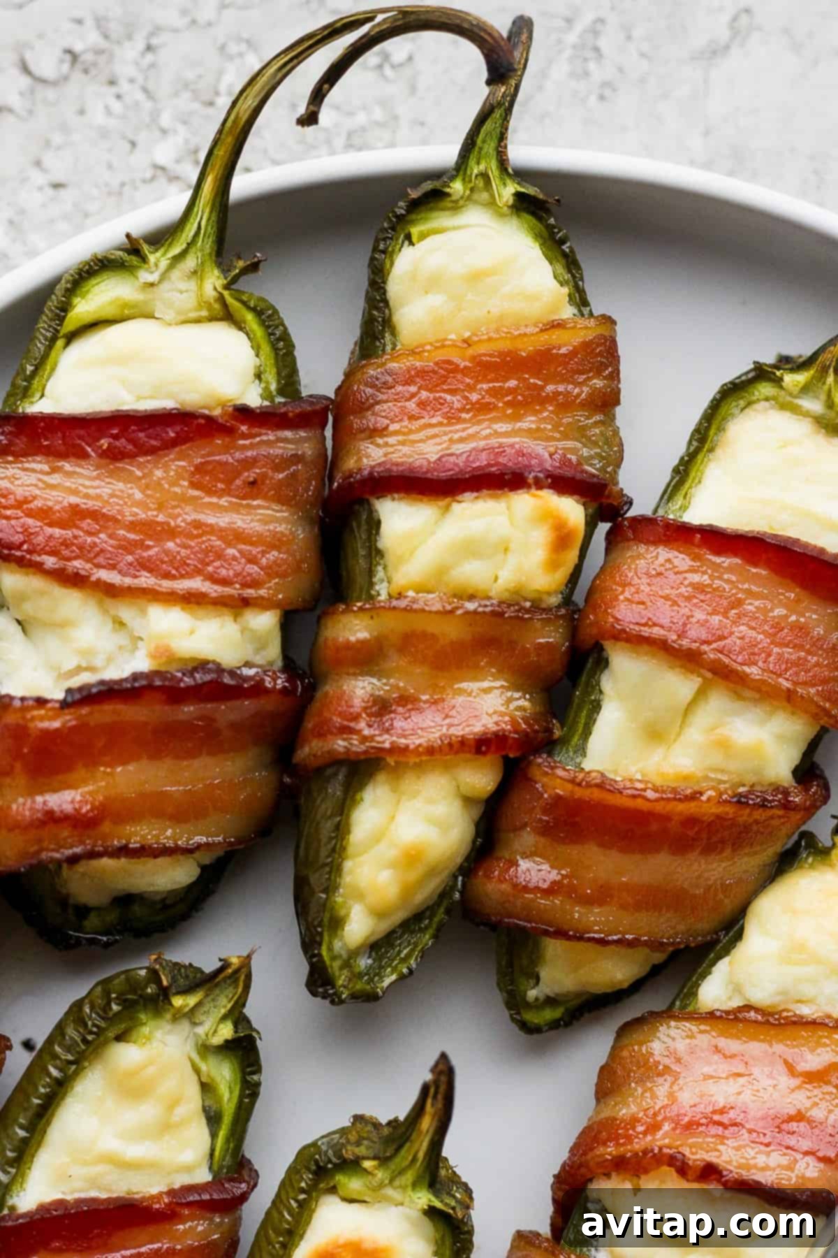 Jalapeno poppers served on a plate, garnished with fresh herbs.