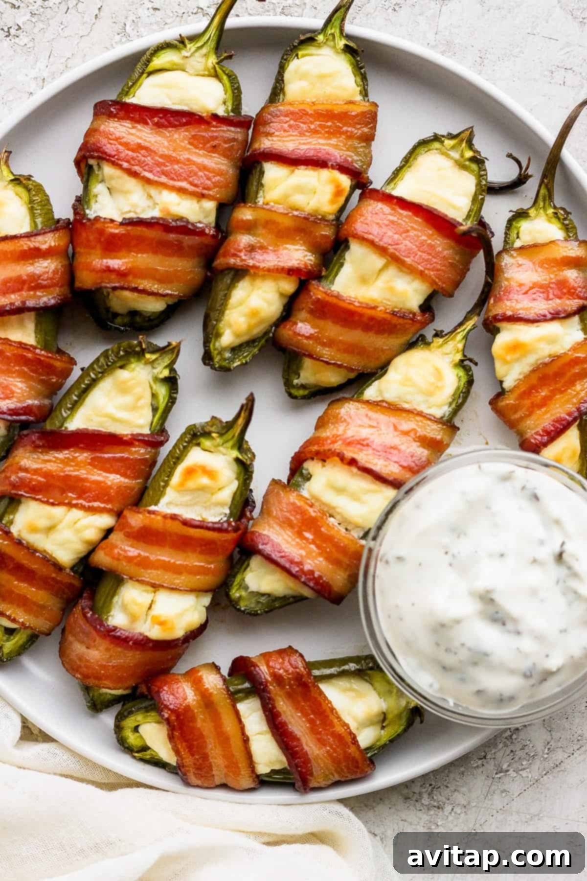A plate piled high with crispy bacon-wrapped jalapenos, ready to be served.