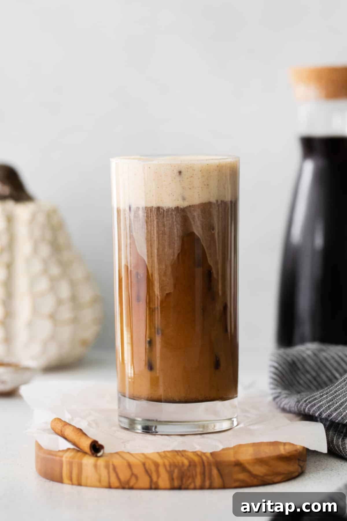 Velvet Pumpkin Cold Brew 7 Close-up of a perfectly poured Pumpkin Cream Cold Brew in a glass, with the distinct layers visible and ice cubes.