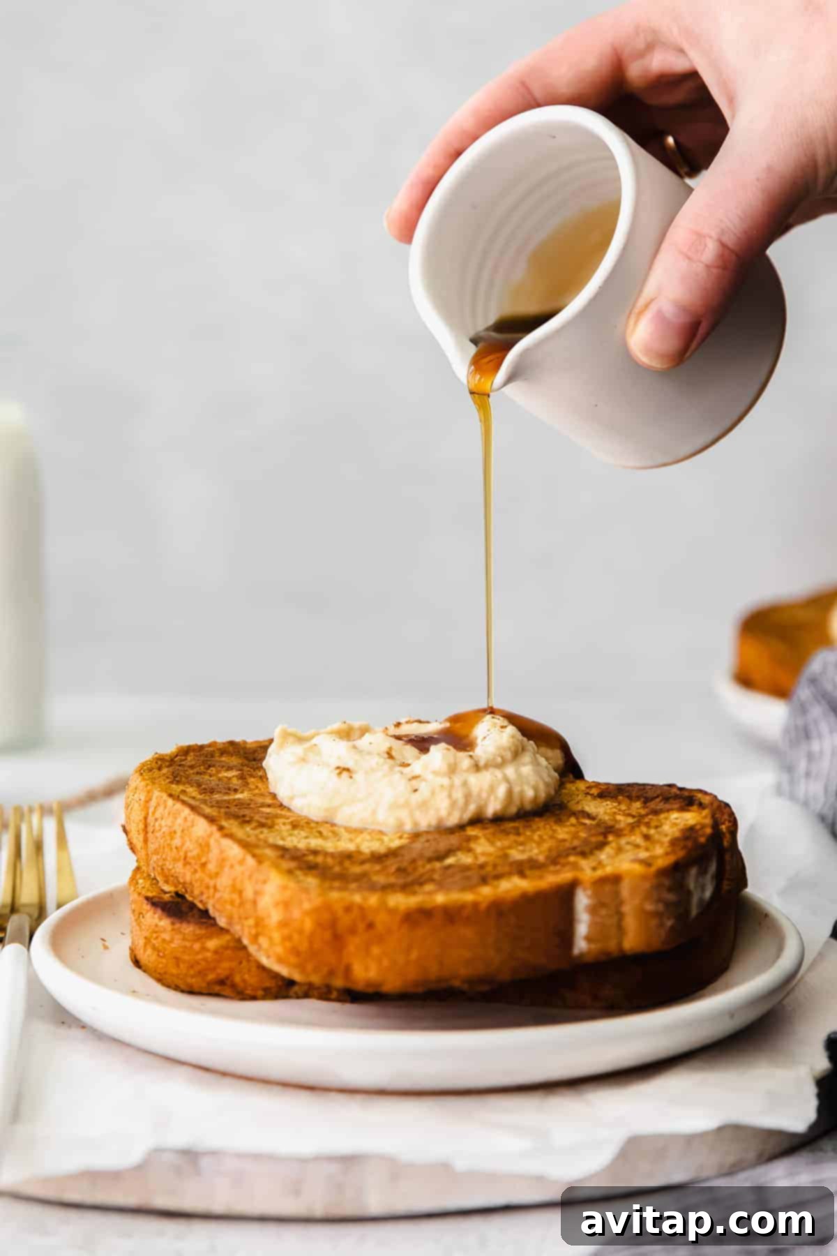Drizzling rich maple syrup over a stack of golden pumpkin French toast.