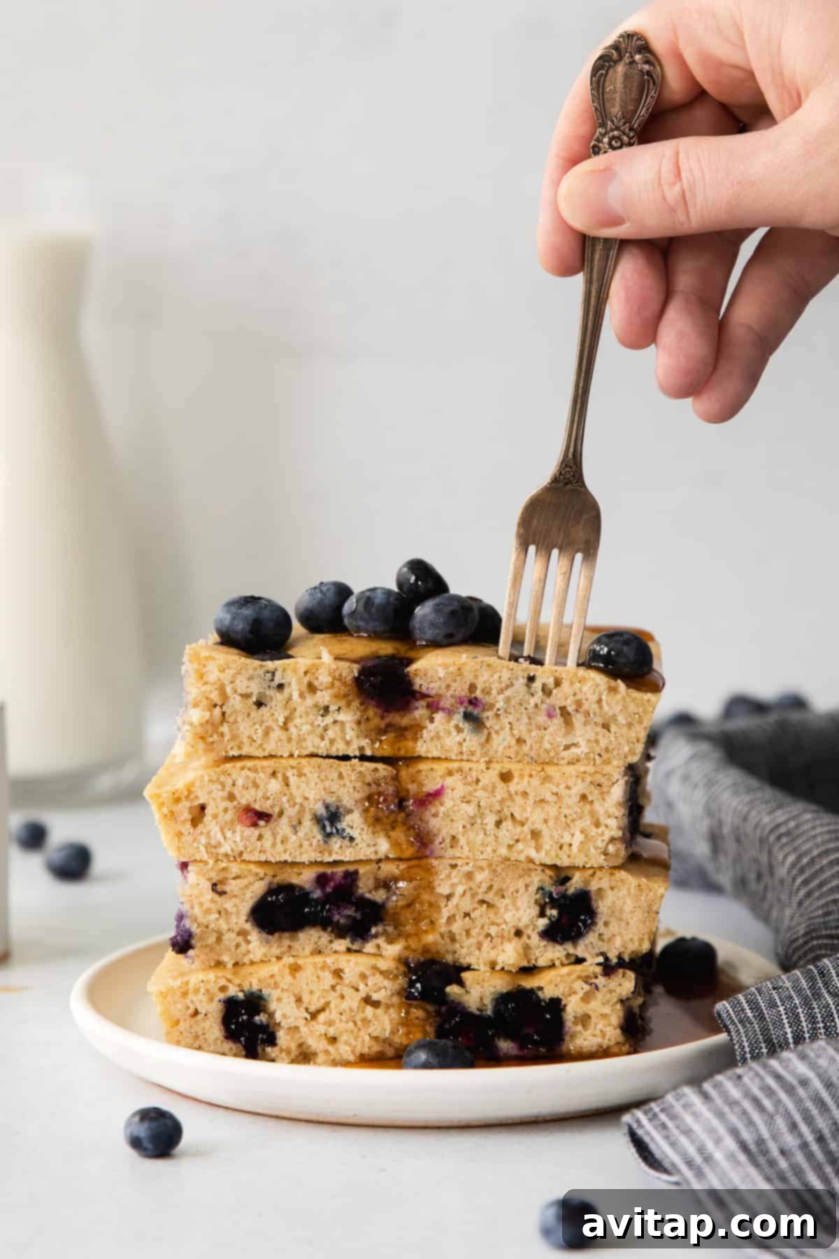 A stack of golden, fluffy blueberry pancakes ready to be served.