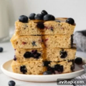 A stack of fluffy blueberry pancakes on a plate, ready to eat.