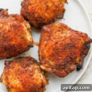 A perfectly cooked and crispy air fryer chicken thigh on a white plate, ready to be enjoyed.