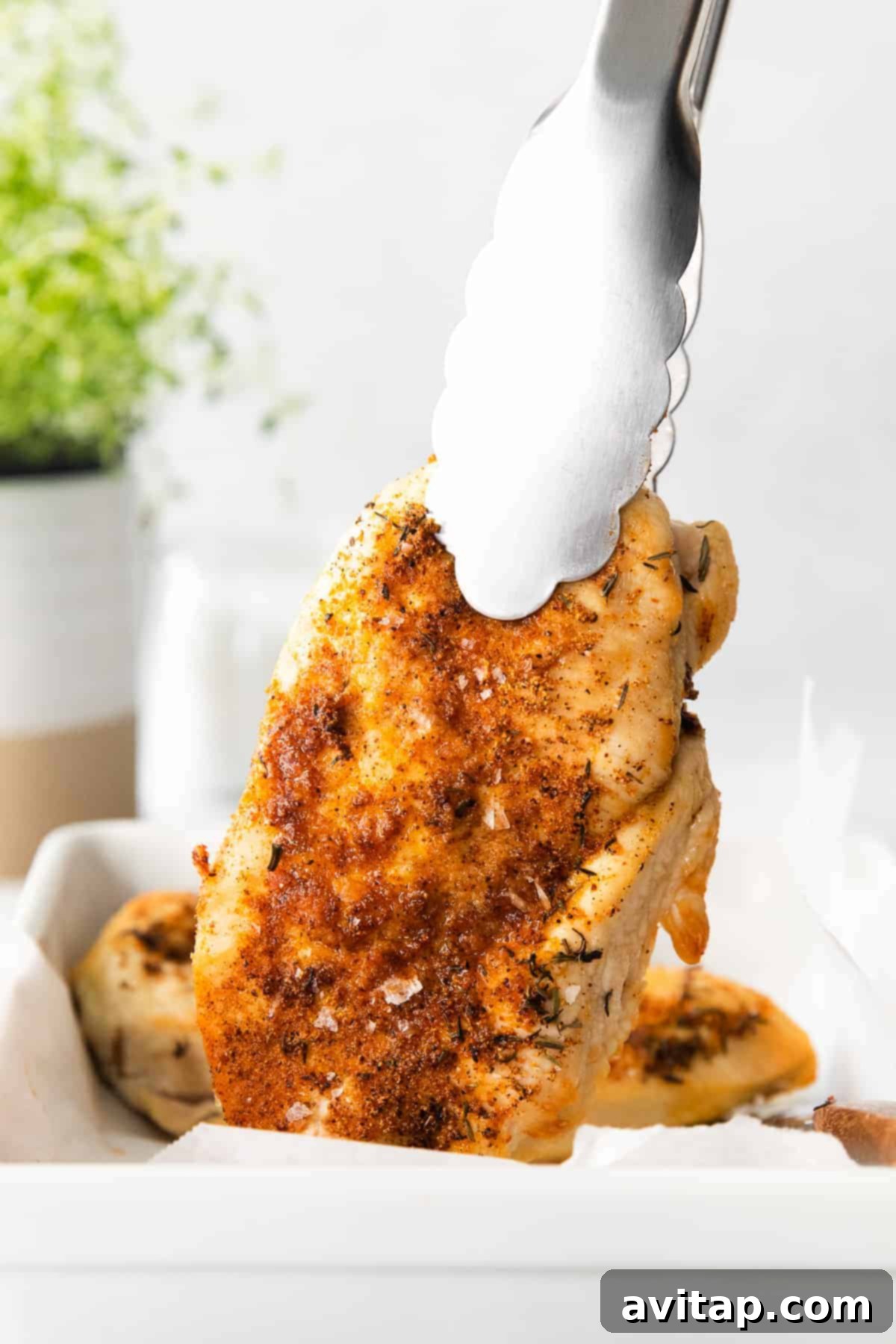 Two perfectly cooked air fryer chicken breasts in a serving dish.