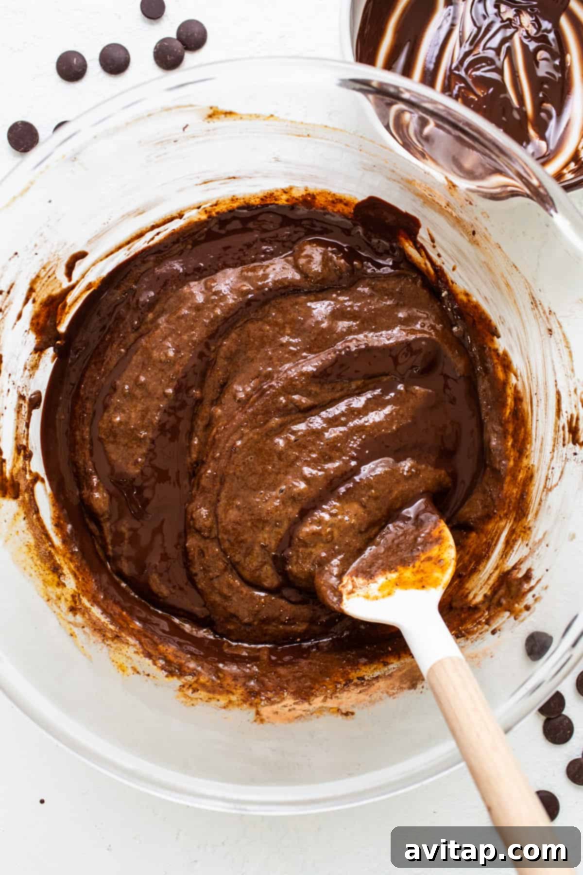 A close-up shot of a rich, chocolatey bowl of brownie batter, revealing the perfect fudgy consistency.