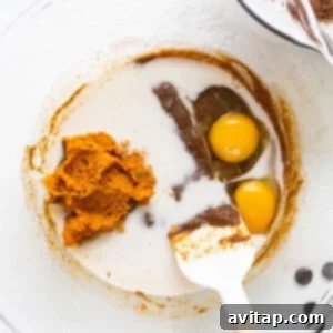 A white plate topped with dark chocolate and two eggs, ready to be mixed into the batter.