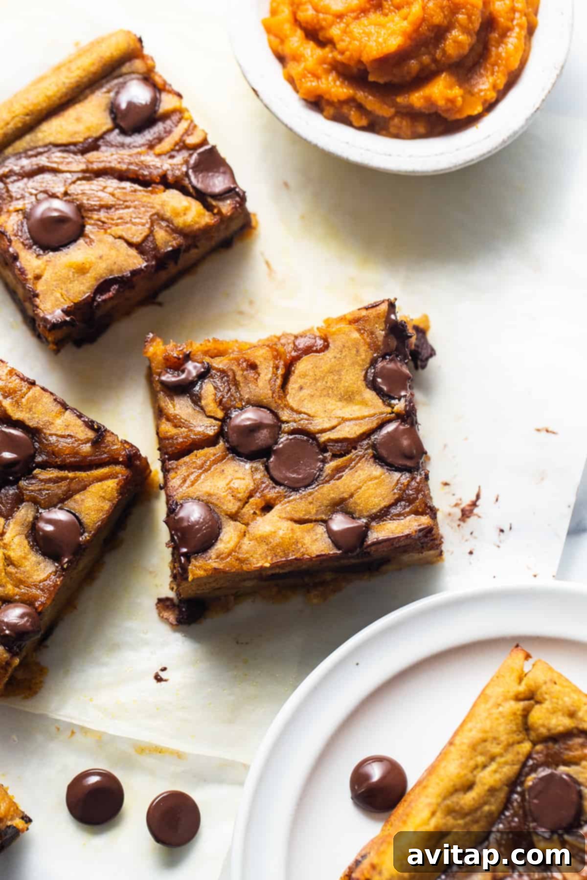 Golden-brown chocolate chip cookie bars arranged on a pristine white plate.