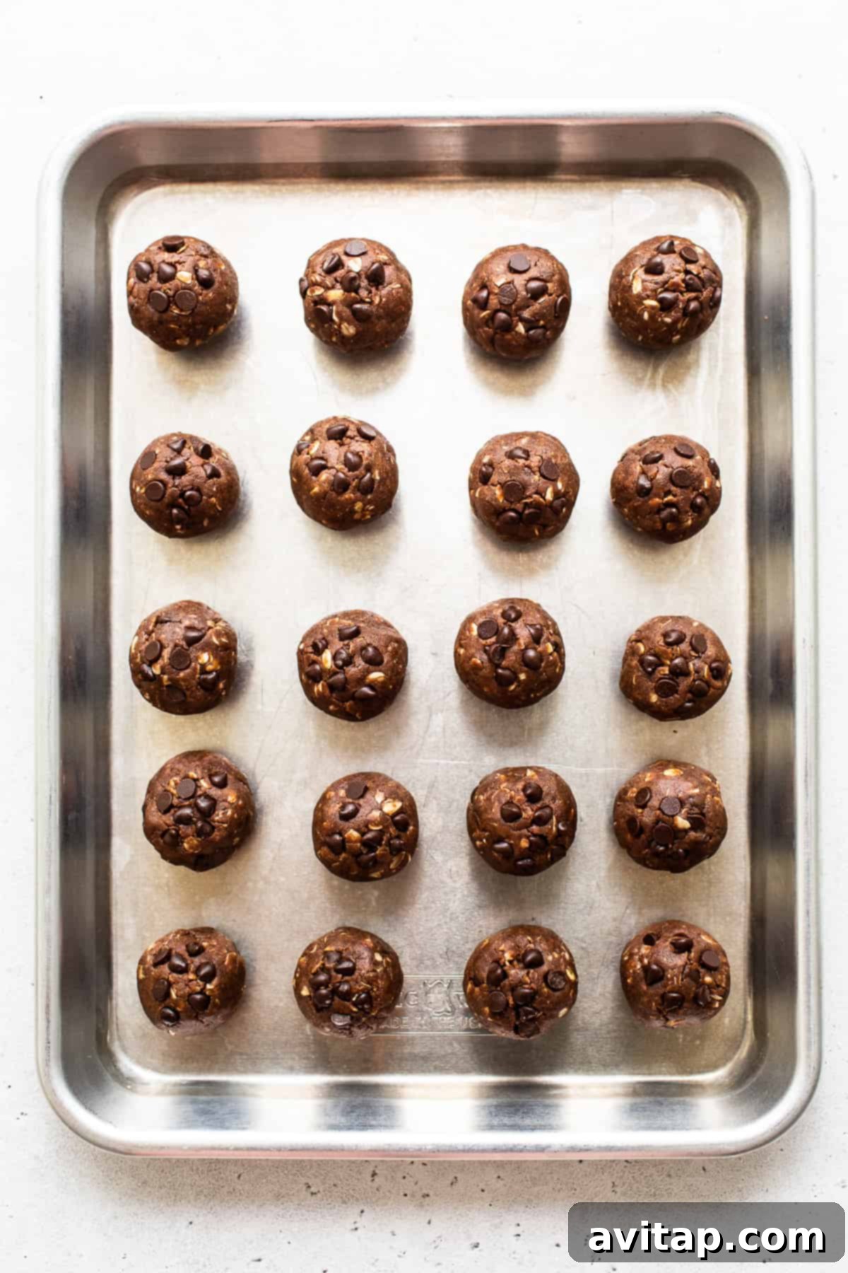 Freshly rolled Mint Chip Protein Balls arranged in neat rows on a baking sheet, ready for chilling.
