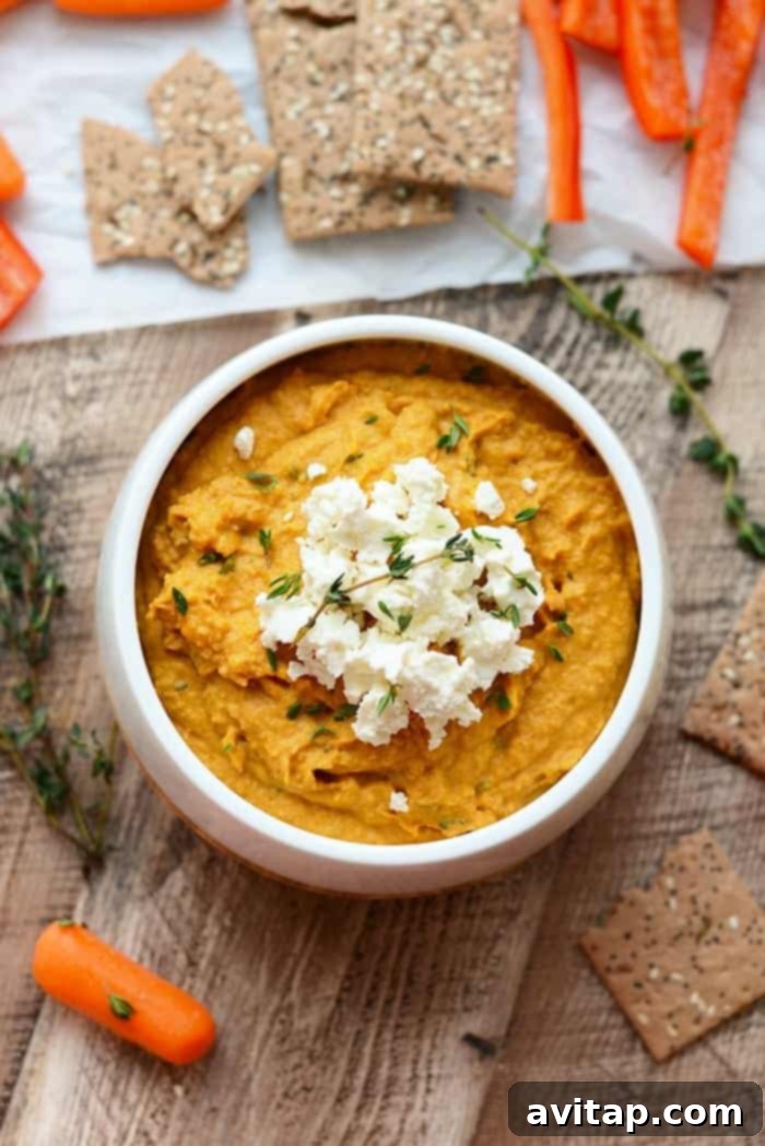 Gourmet Sweet Potato Hummus with Goat Cheese Sweet potato hummus topped with goat cheese in a white bowl, ready to be served as a gourmet dip.