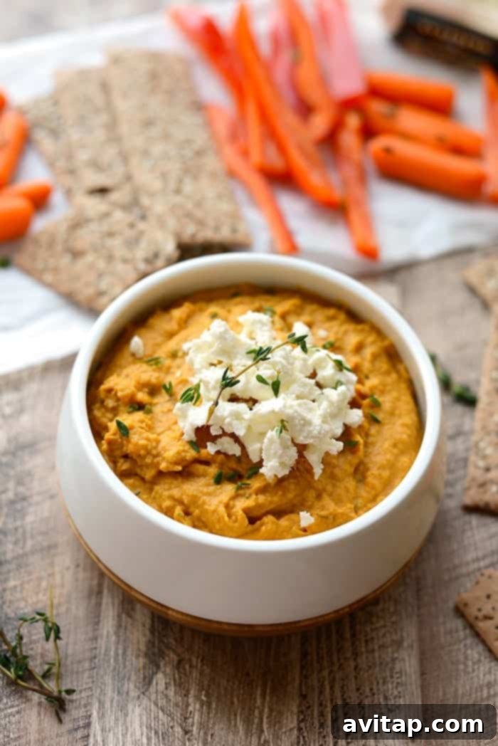 Freshly Made Sweet Potato Hummus Ready to Enjoy A close-up of smooth homemade sweet potato hummus in a white bowl, garnished and ready to serve.