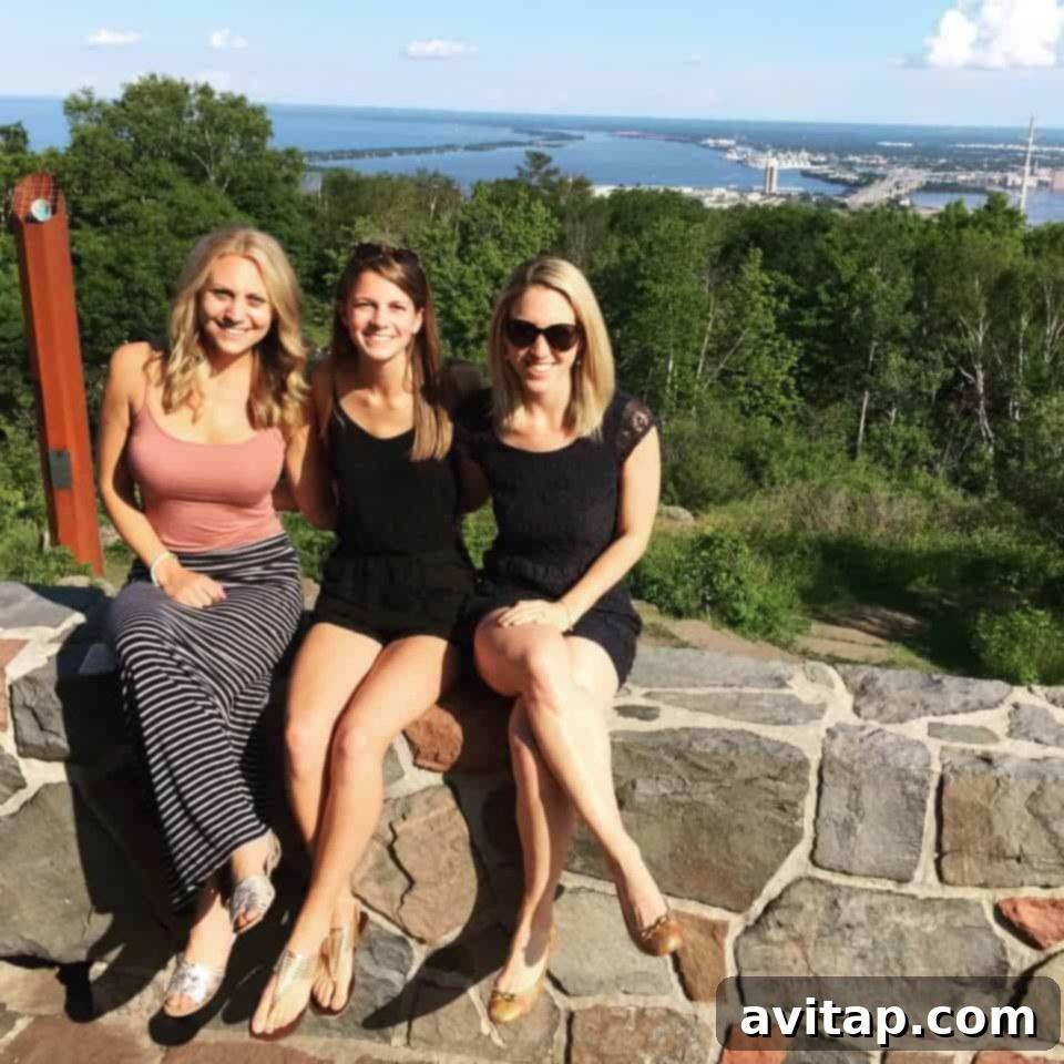 Golden Sweet Potato Hummus 3 Three joyful women sitting together on a rock wall, overlooking a scenic view in Duluth, Minnesota. The image captures a moment of friendship and natural beauty.