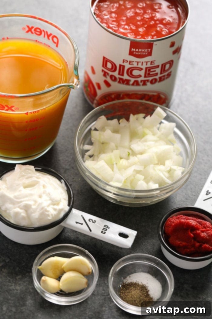Essential Ingredients for a Speedy & Healthy Tomato Bisque A vibrant array of fresh ingredients for tomato basil bisque, including ripe tomatoes, basil leaves, onion, and garlic, displayed on a wooden board, ready for preparation.