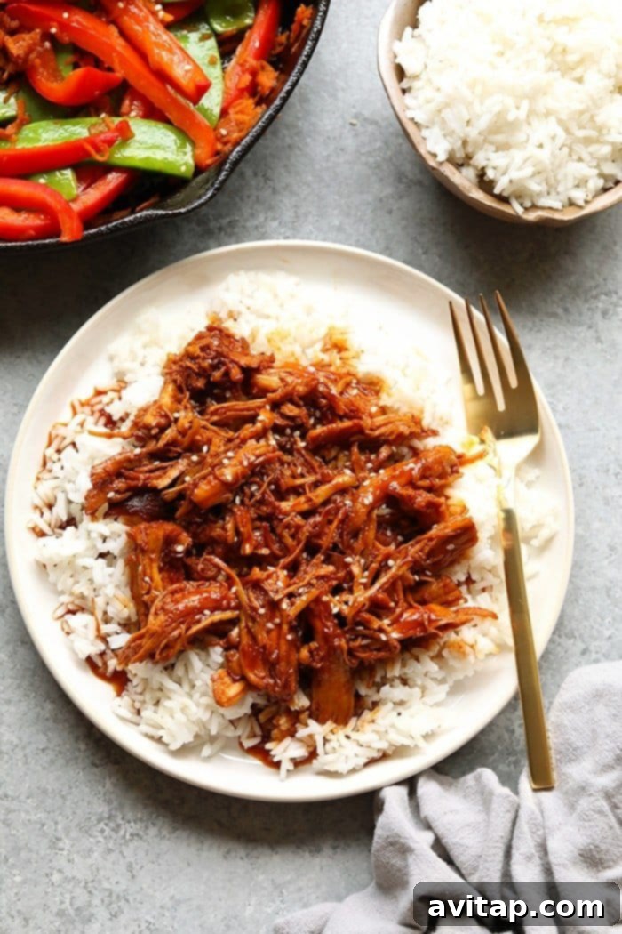 Shredded Honey Sriracha Chicken on a plate, garnished