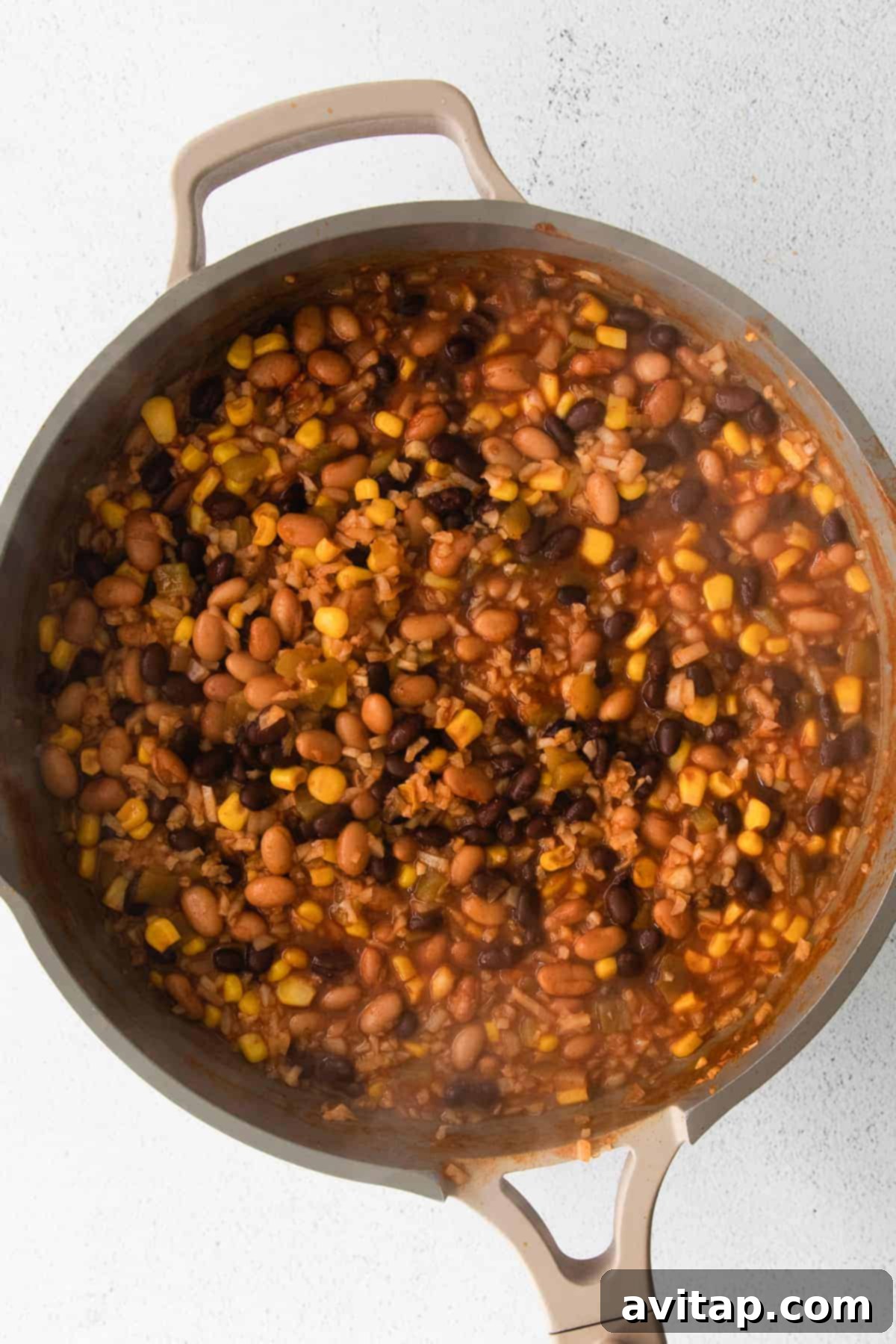 The cauliflower taco skillet in a pan, still bubbling, with cheese melted over the top.