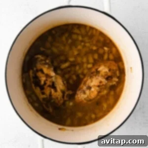 chicken and beans in a pot on a white background.