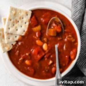 chili in bowl with crackers and a spoon.
