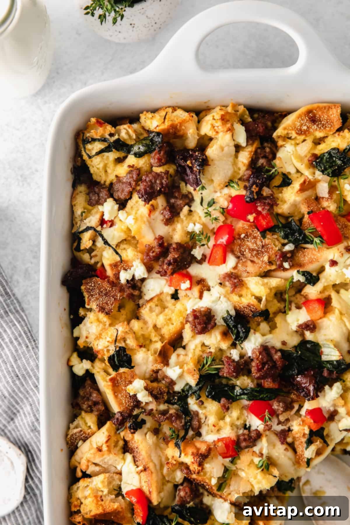 Close-up of English muffin breakfast bake adorned with fresh thyme sprigs.
