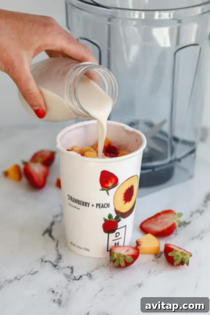 milk being poured into a Daily Harvest smoothie cup, ready for blending