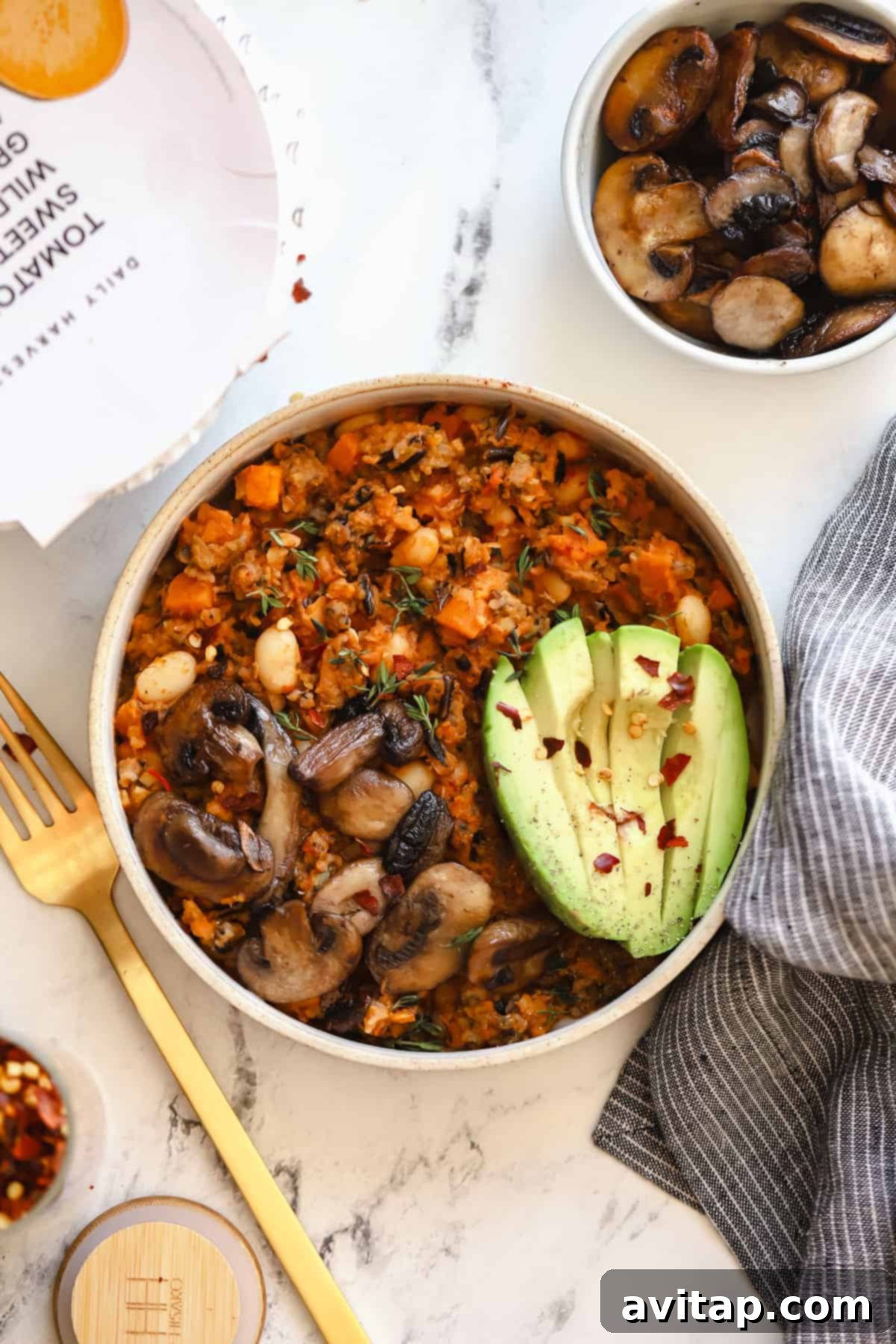 finished Daily Harvest harvest bowl topped with fresh avocado and sliced mushrooms