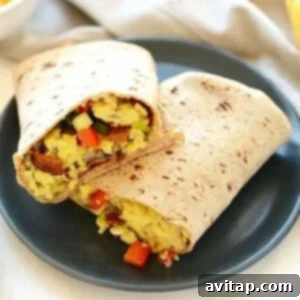 A breakfast burrito on a plate.