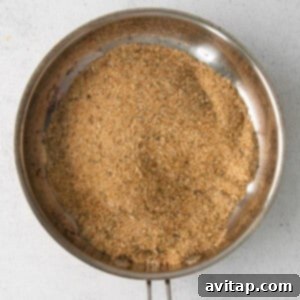 A frying pan with seasoned breadcrumbs toasting until golden brown.