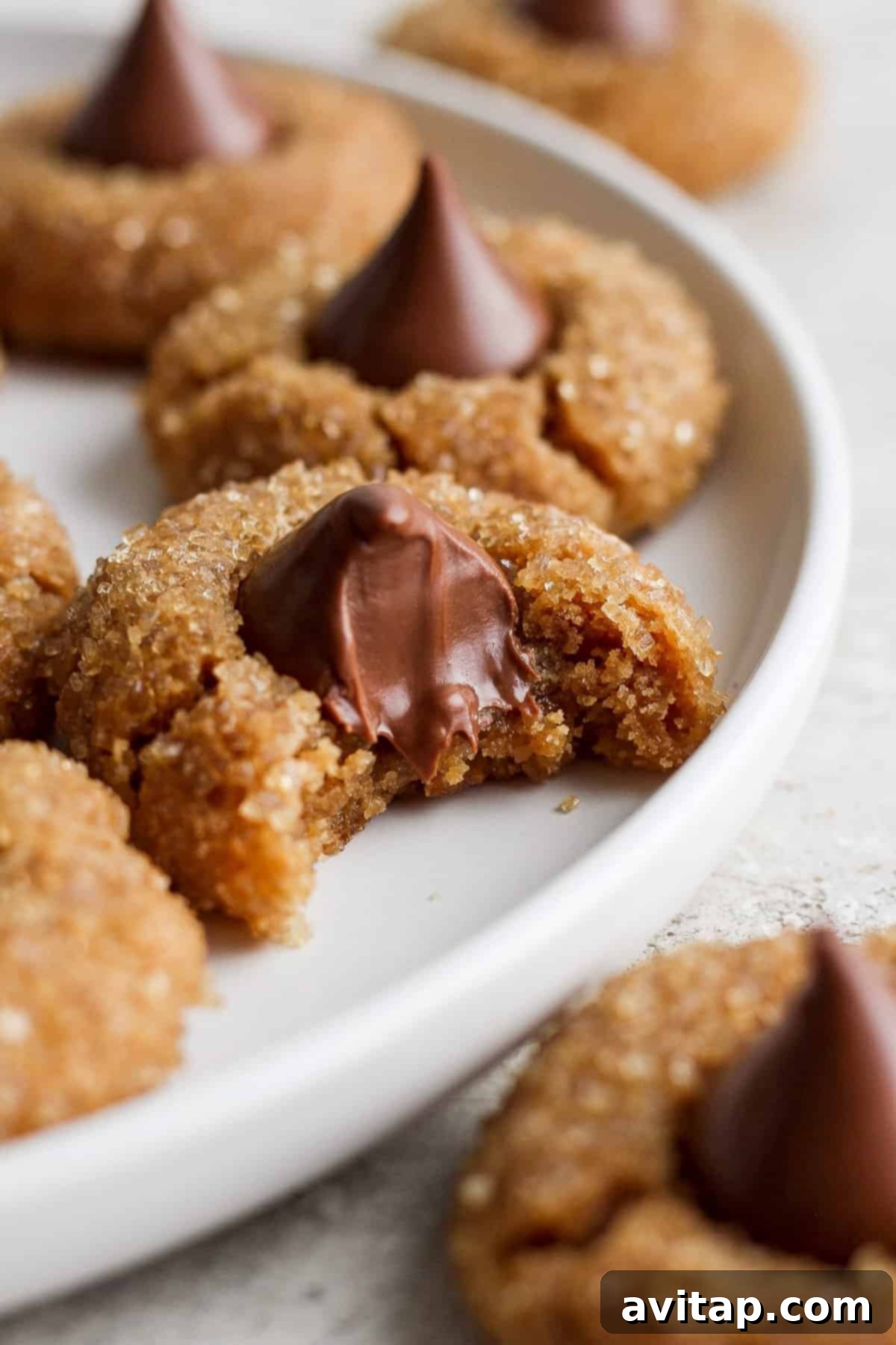 Ultimate Flourless Peanut Butter Blossoms 7 A freshly baked peanut butter cookie with a bite taken out, showing its soft and chewy interior.