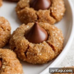 Peanut butter cookies with chocolate kisses on a plate.
