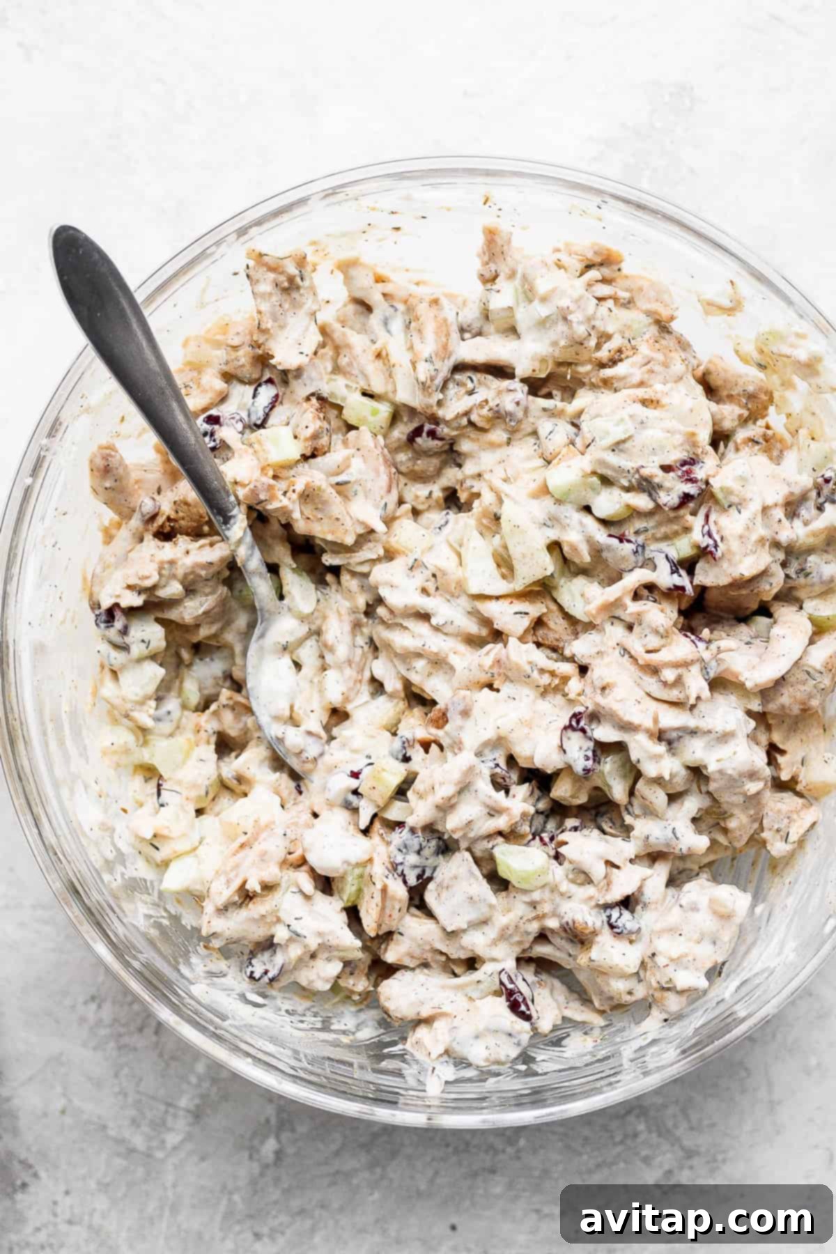 Close-up photograph of freshly prepared turkey salad, distinctly showing the texture of the shredded turkey, vibrant cranberries, and crunchy walnuts.